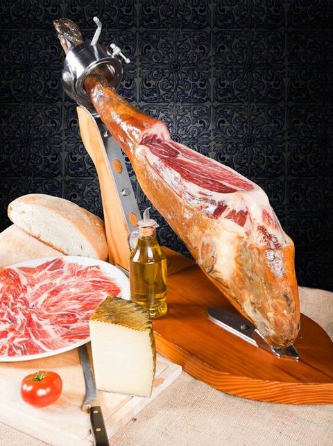 Jamón ibérico en su jamonero, con queso, pan y aceite