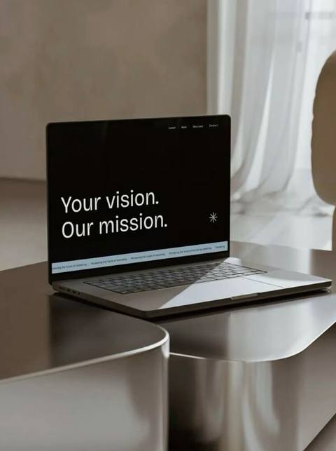 Portátil abierto con una web en pantalla, sobre una mesa